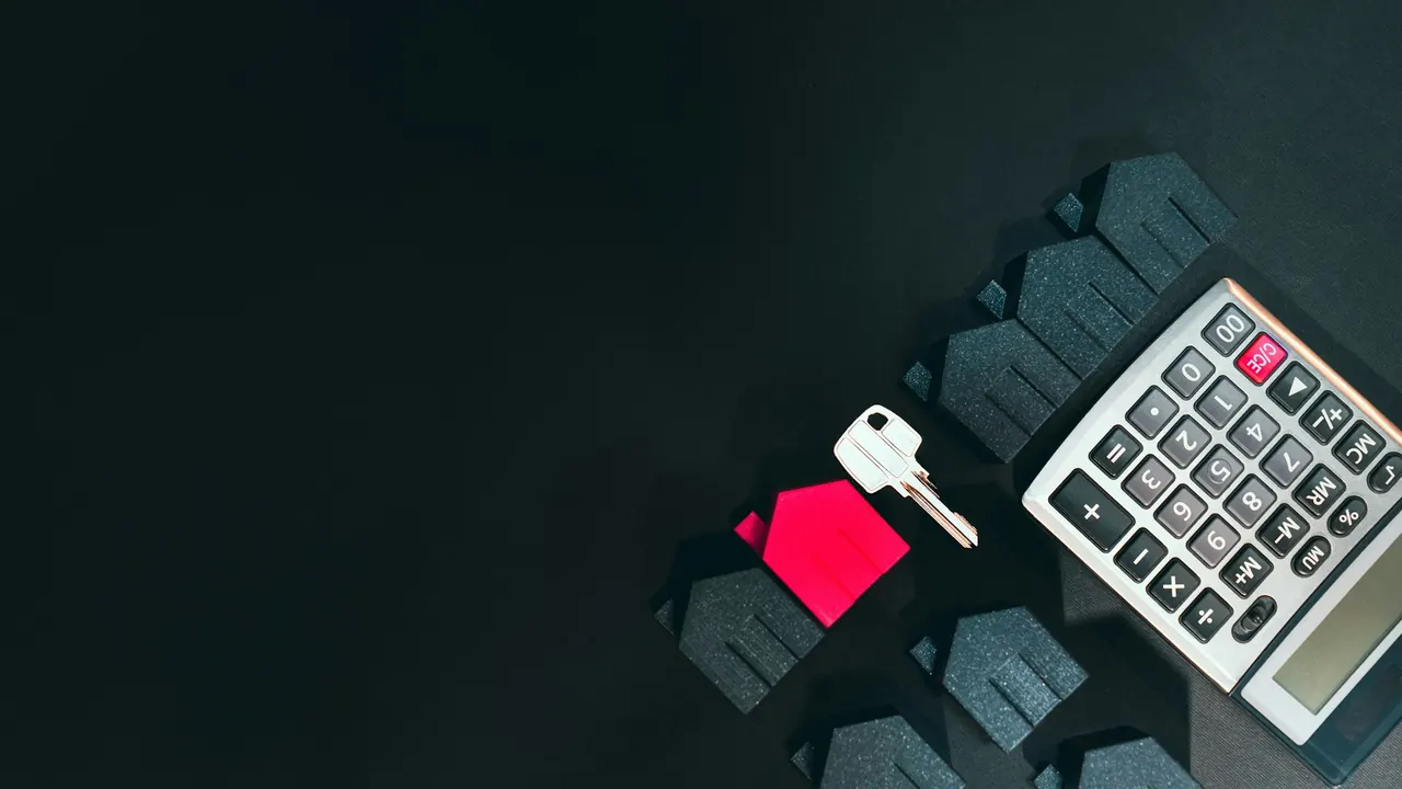 House key, model homes, and calculator arranged for a pricing conversation